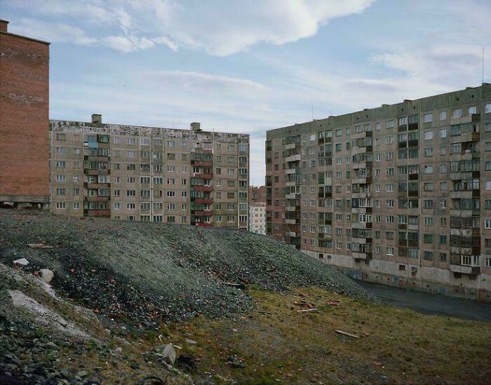 Gray, deteriorating apartment blocks in a bleak urban environment
