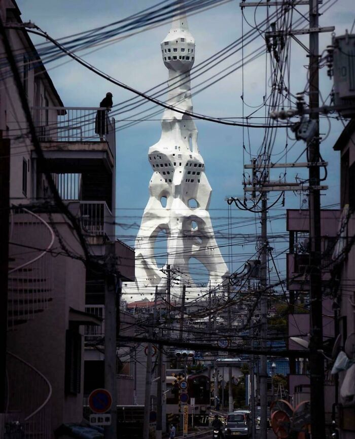 Unusual tower rising behind tangled electric wires in city