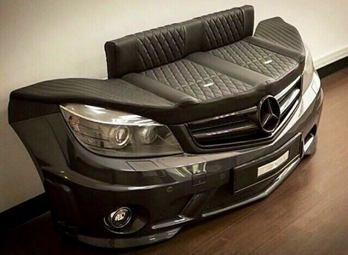A creative couch crafted from the front bumper of a Mercedes-Benz car with black quilted leather seating, inspiring interior designers.