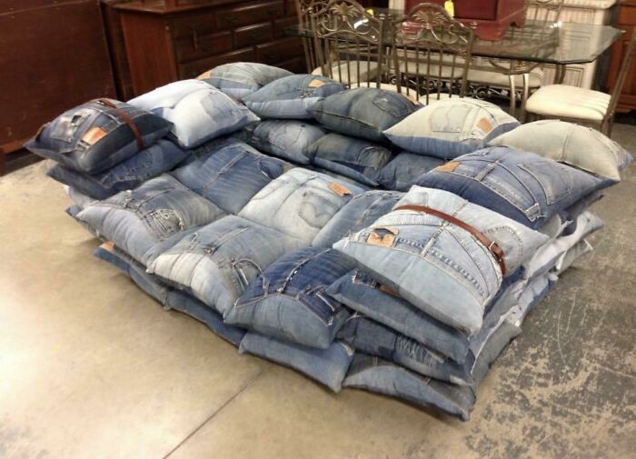 A large couch made from many denim jean pillows, a creative and unique interior designer furniture piece.