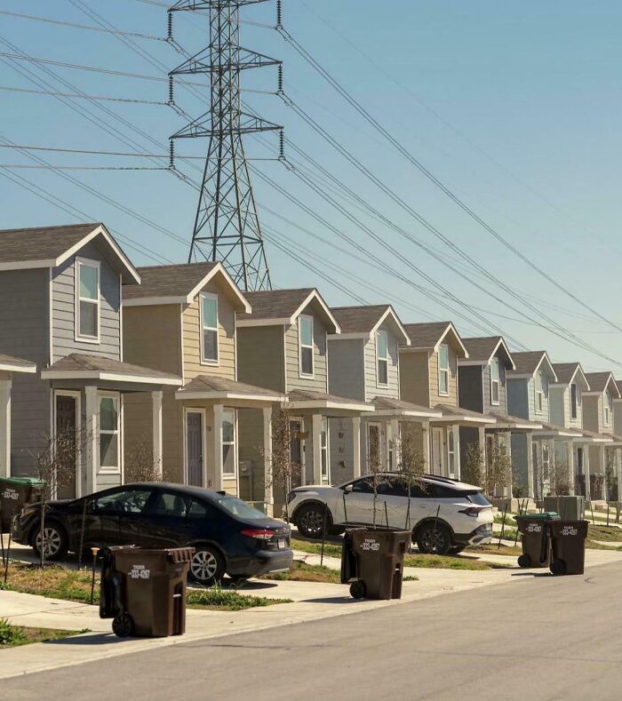 Row of suburban houses under high tension power lines in urban neighborhood