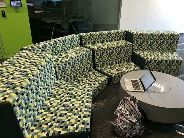 A unique sectional couch with a green, black, and yellow geometric pattern, ideal for interior designers seeking bold couches.