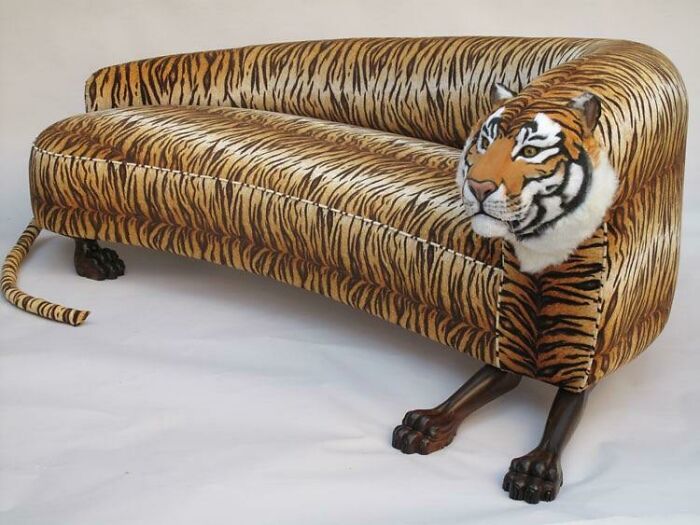 A distinctive tiger-print couch with a realistic tiger head and paws, a wild statement for interior design.