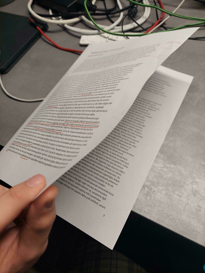 A student reviewing a physical paper, possibly highlighting issues with toxic and annoying teachers.