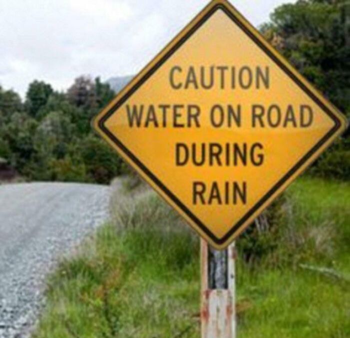Funny warning sign cautioning water on road during rain