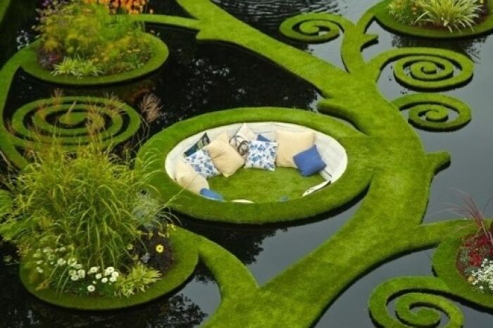 An outdoor couch set on a floating grassy island, an inventive design that would appeal to any interior designer.