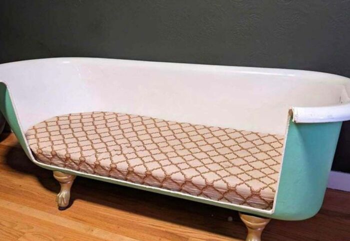 Repurposed bathtub turned into a cozy couch with a patterned cushion, ideal for unique interior design.