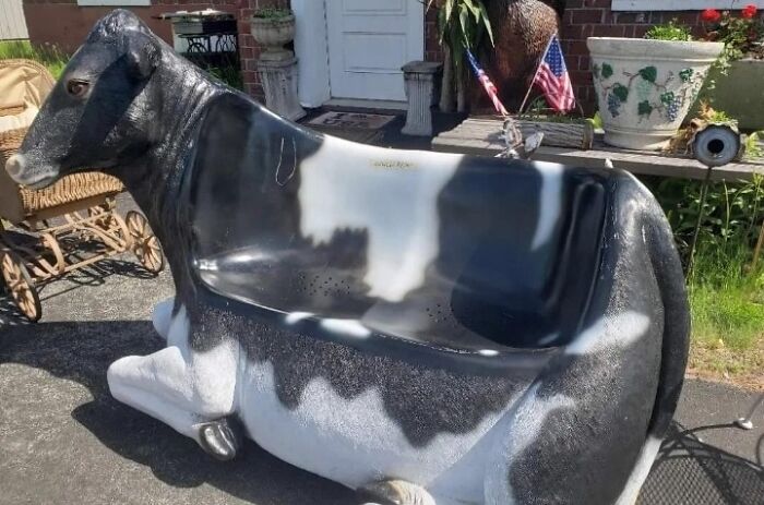 A unique couch shaped like a black and white cow, offering a quirky interior design statement.