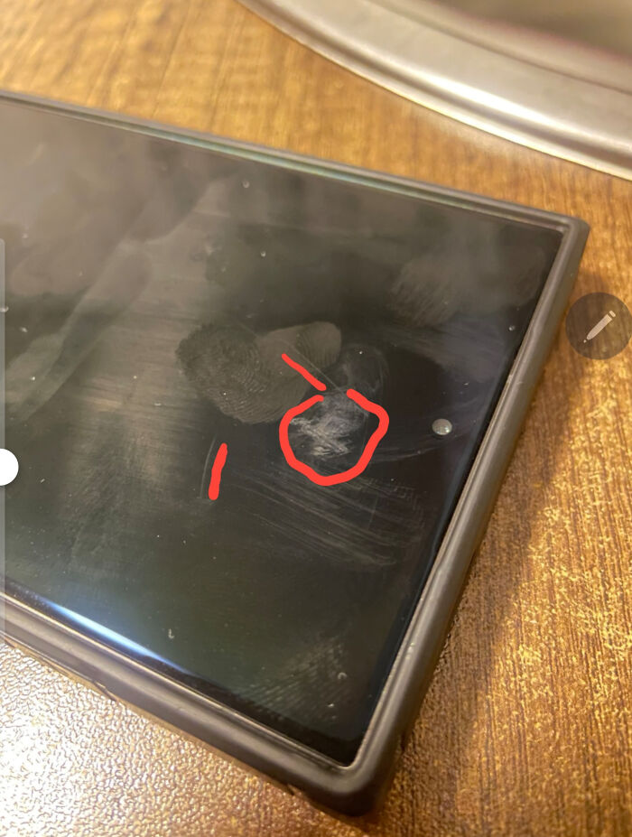A dirty phone screen with smudges and a red circle drawn on it, perhaps from a toxic teacher's remark.