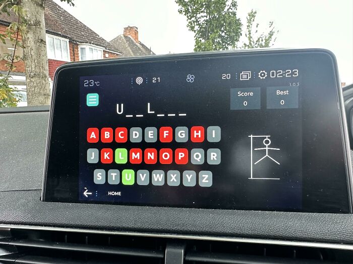 A car's infotainment screen displaying a Hangman-style brain puzzle with 'U_L_____' as the word.