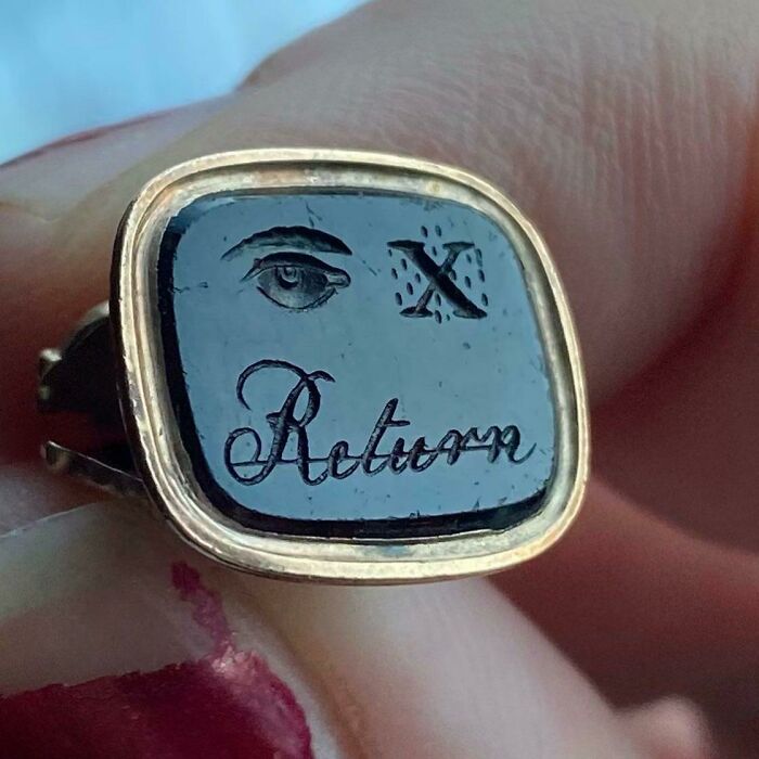 An antique ring with an eye, the letter X, and the word 'Return' engraved, posing a brain puzzle.