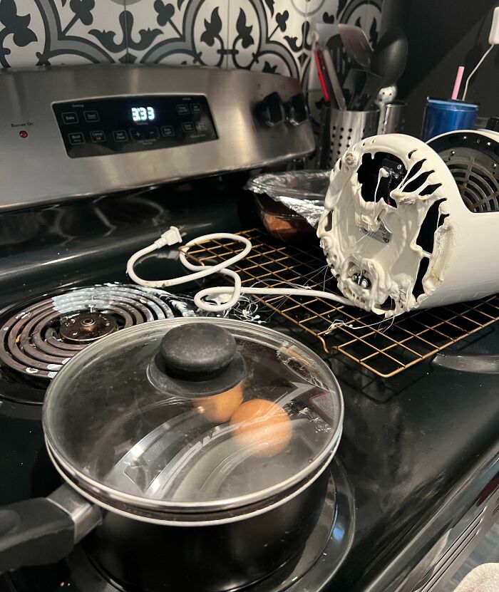 Kitchen stove with melting appliance and eggs boiling in pan, funny or cringe fail cooking accident