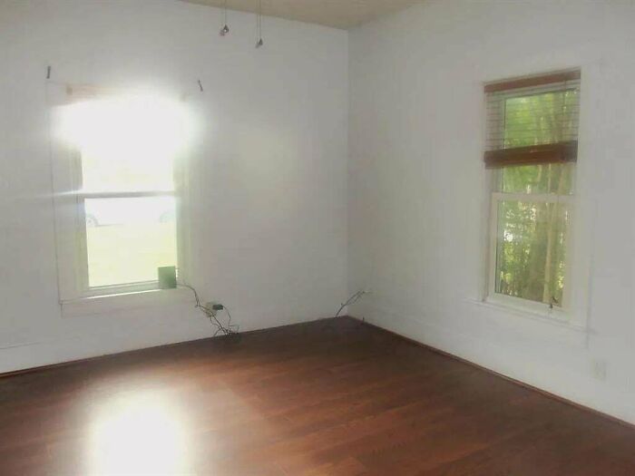 An empty room with white walls and wooden floors, awaiting home decor projects to transform its look.