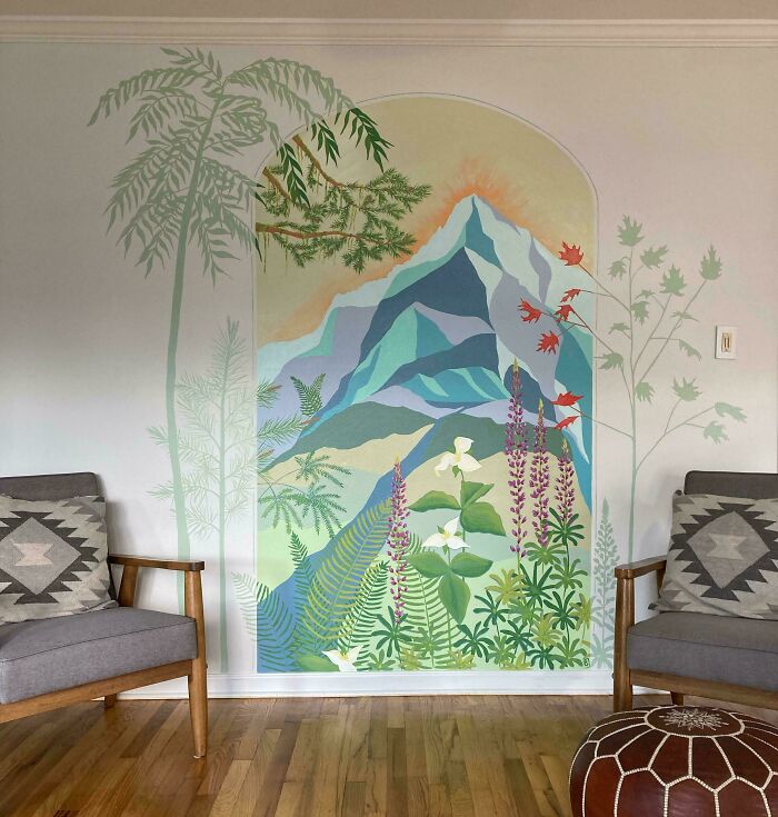 A vibrant home decor project featuring a large wall mural of a mountain landscape with palm trees and flowers, flanked by two gray chairs, creating a stunning focal point.