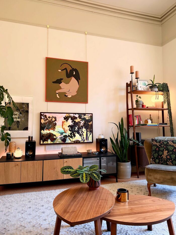 A cozy living room featuring modern home decor projects with artistic flair, a sleek media console, and various plants.