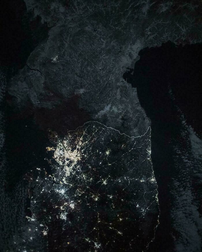 Satellite image showing South Korea lit up at night next to a dark North Korea