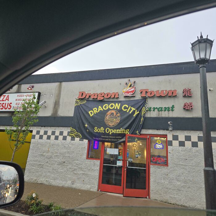 The Dragon City restaurant with a soft opening banner, a mildly interesting picture of storefront.