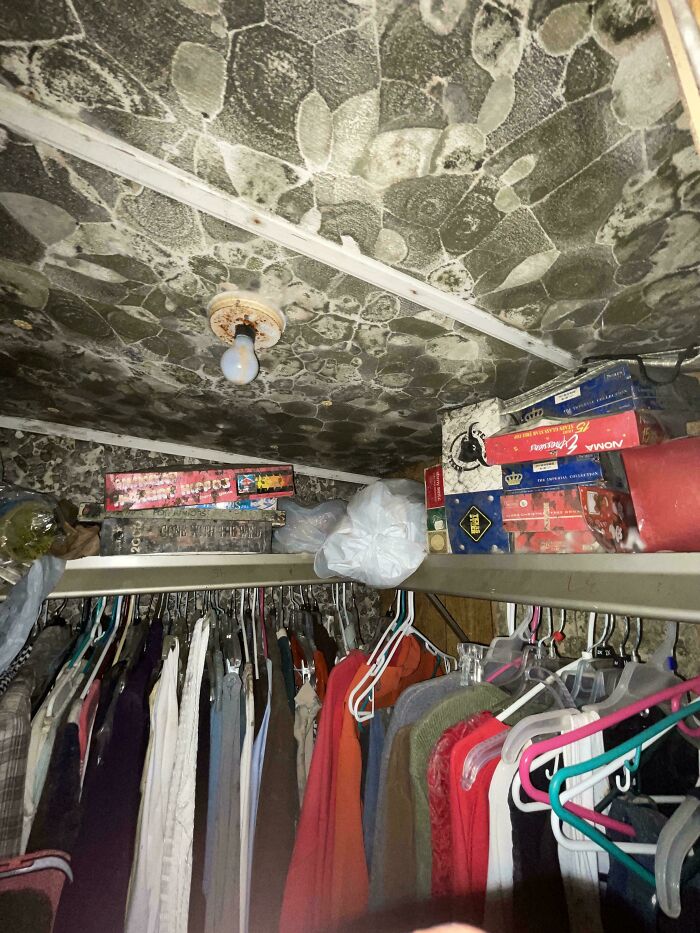 A cluttered closet with a uniquely textured ceiling, an interesting picture showcasing an unusual interior.