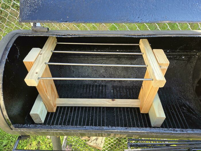 Homemade wooden rack with metal rods inside a large metal smoker, a setup that may be among dangerous things.