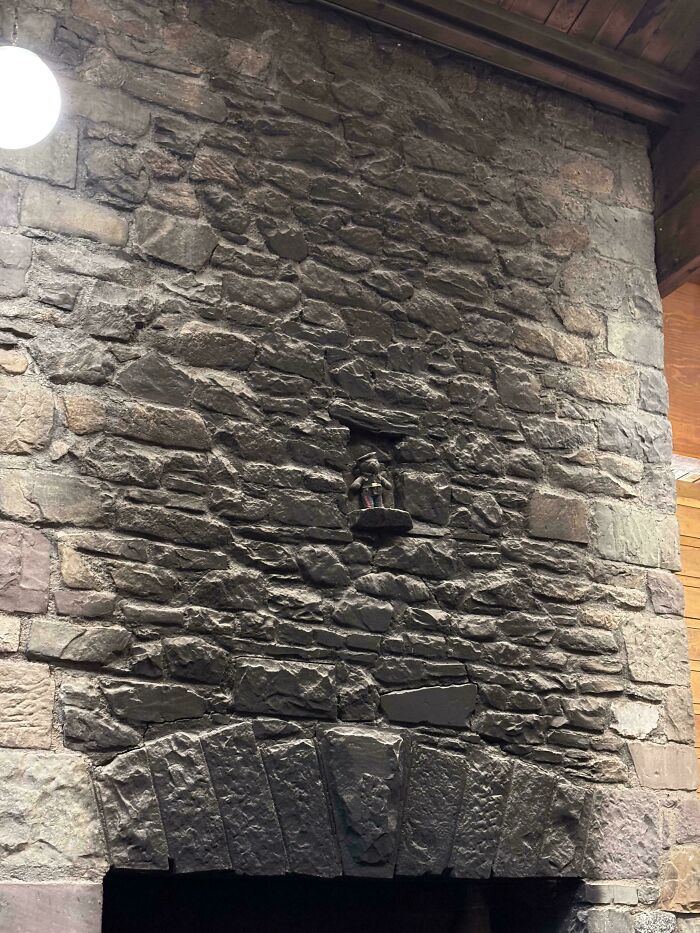 A large stone fireplace with a small, dangerous alcove containing a figurine, an unnecessary design.