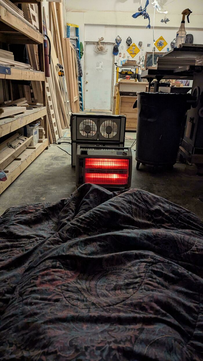 A blanket lies in front of a red space heater and two fans in a workshop, illustrating dangerous things people did.