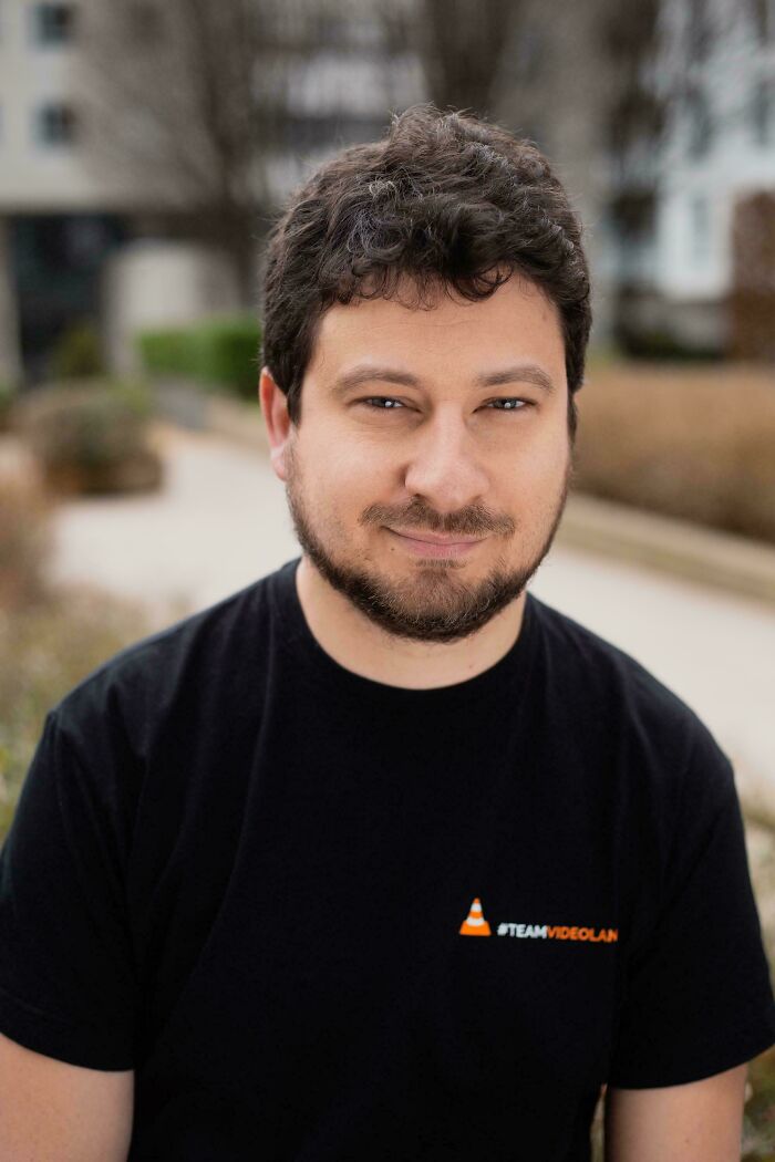 A man with a beard wearing a black t-shirt, looking at the camera, a fascinating pic for a quick brain boost.