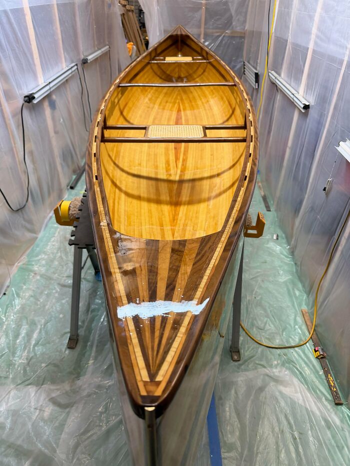 A beautifully crafted wooden canoe with intricate patterns, showcasing a fascinating design and quick facts for a brain boost.