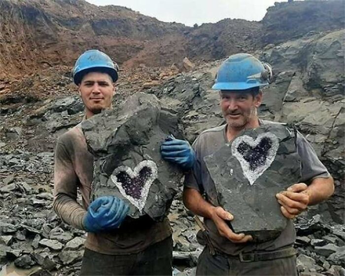 Two miners hold rocks with heart-shaped geodes, providing a fascinating pic and brain boost.