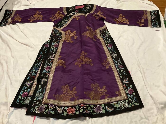 A remarkable antique purple silk robe with intricate gold and colorful floral embroidery.