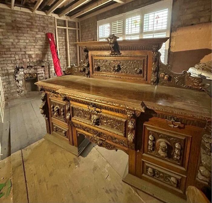 A remarkable antique carved wooden buffet table, full of intricate details, found in an old room.