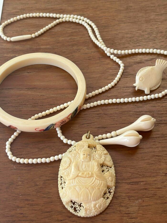 A collection of remarkable antique ivory jewelry including a beaded necklace, Buddha pendant, bracelet, and fish charm.