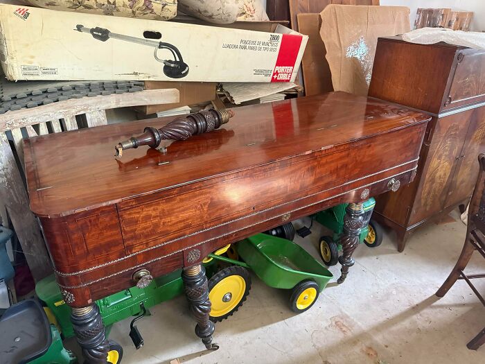 A beautiful dark wood antique table with ornate legs, featuring a decorative spindle on top, remarkable antiques.