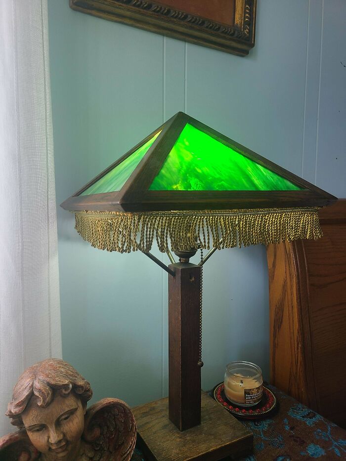A remarkable antique table lamp with a green stained glass shade and fringe, a special find.
