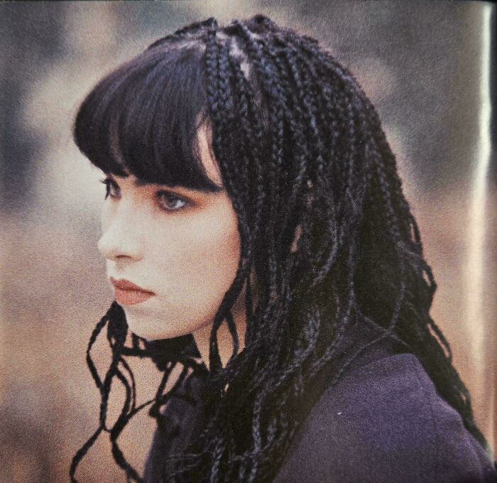A woman with long black braids and bangs, demonstrating a bad hair day.
