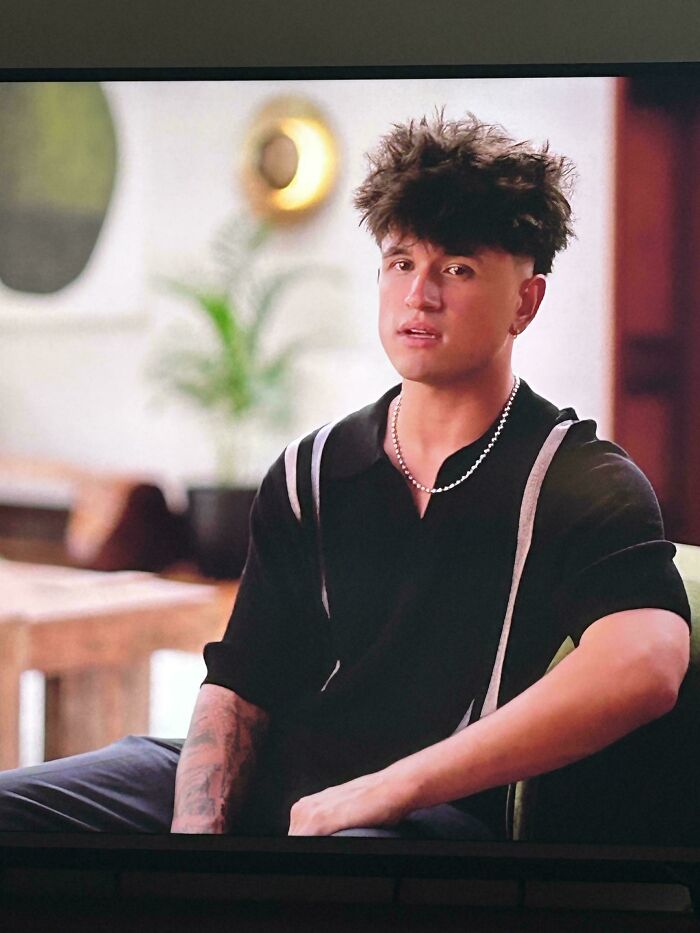 A man with a wild, curly bad hair day, sitting and looking at the camera, going viral for his look.