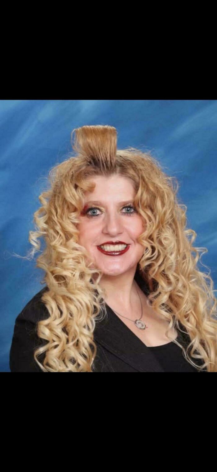 A woman with an extreme bad hair day, featuring a tall, styled blonde fringe and long curly hair.