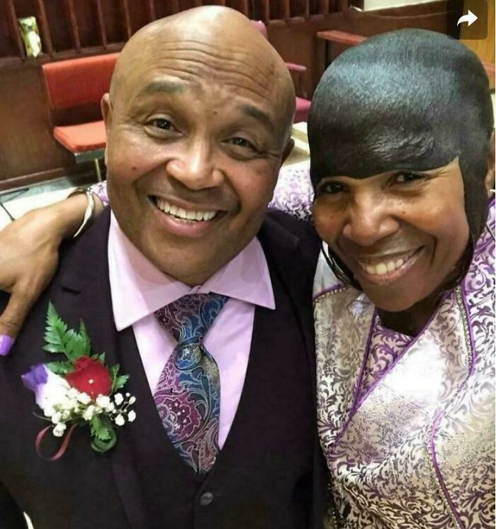 A smiling couple, with the woman sporting a unique and unfortunate bad hair day style that went viral.
