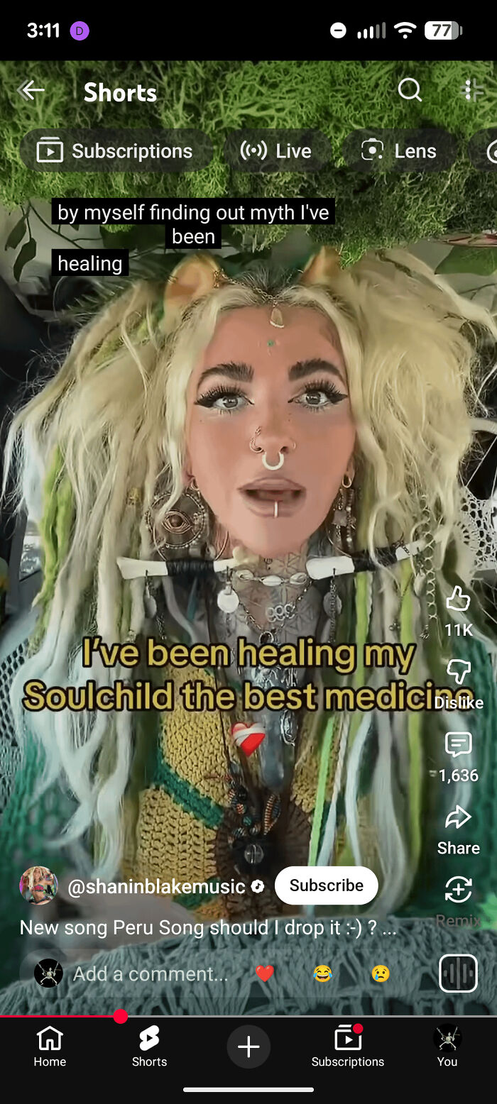 A woman with long, textured blonde and green hair, styled wildly, creating an eccentric bad hair day look.