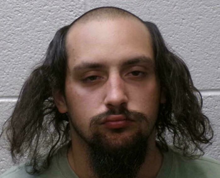 A man with a receding hairline and long hair on the sides, creating a bad hair day look, goes viral.