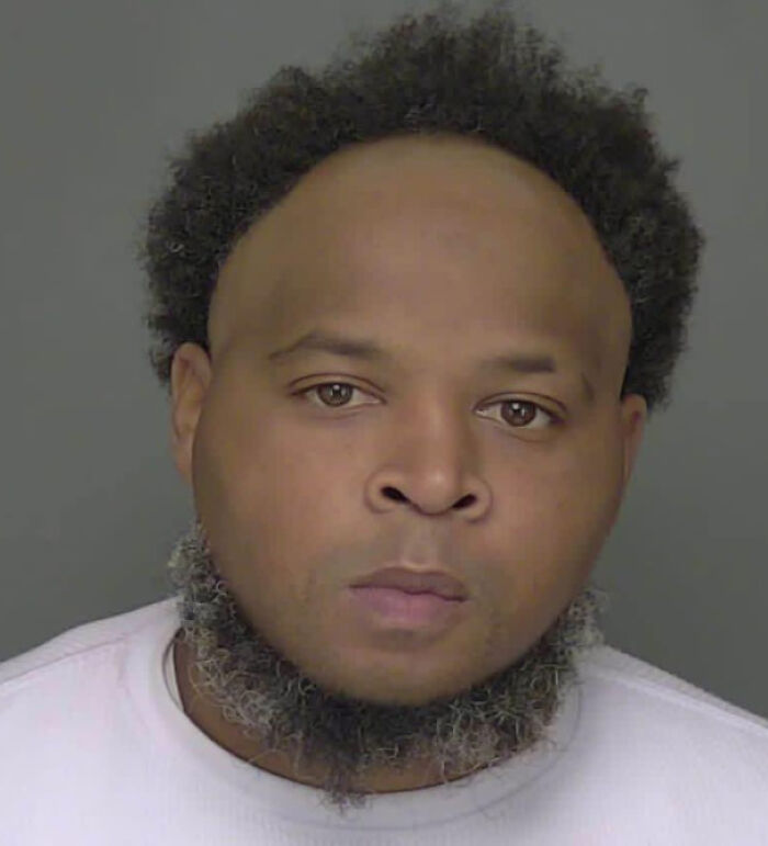 Mugshot of a man with an unusual haircut, a bad hair day.