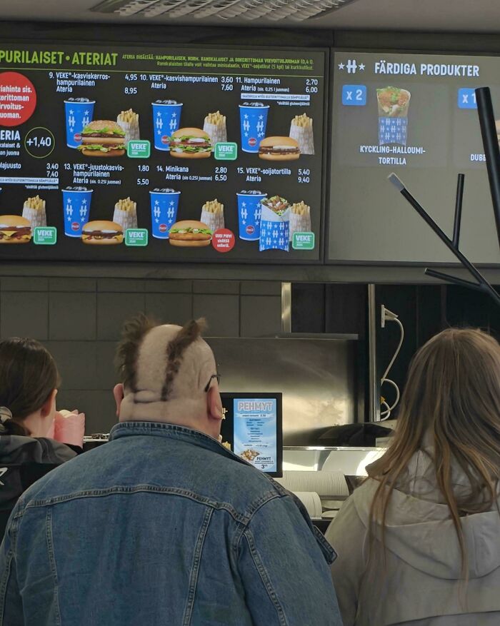 A man with a unique haircut at a fast food restaurant, representing a bad hair day.
