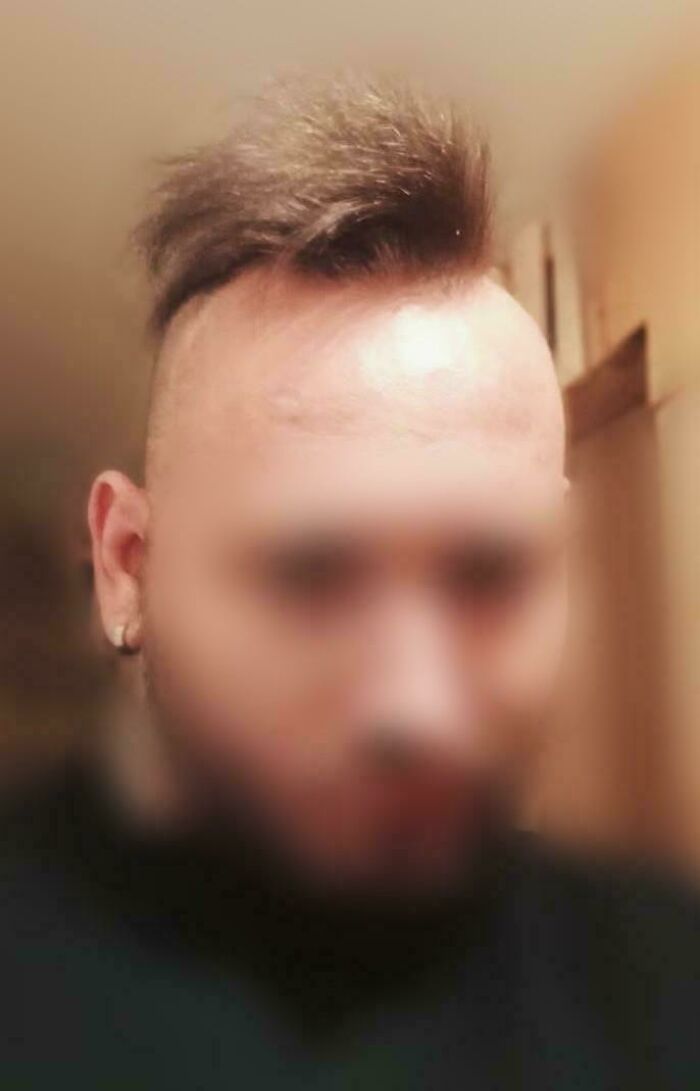 A person with a blurry face and a bad hair day, featuring a short, spiky mohawk.