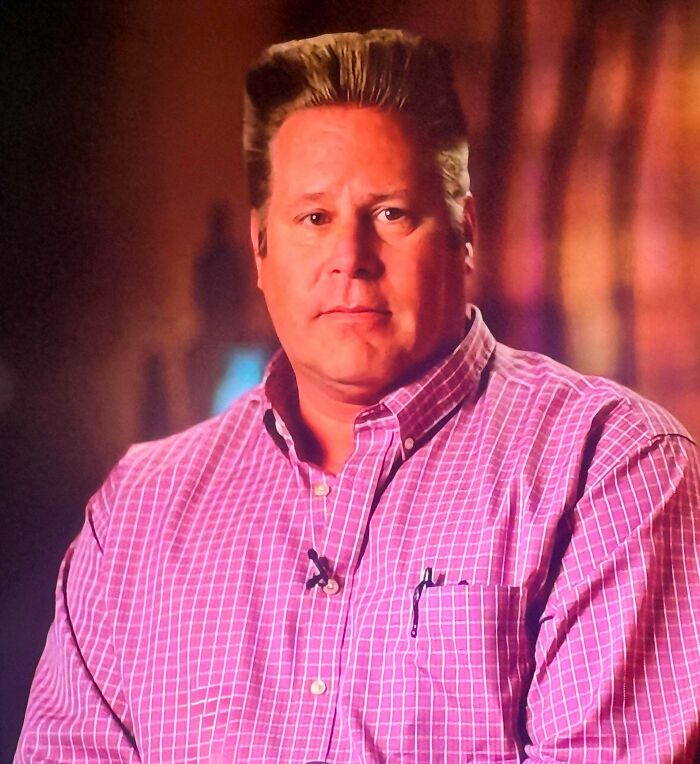 A man with a high, slicked-back hairstyle, demonstrating a bad hair day.