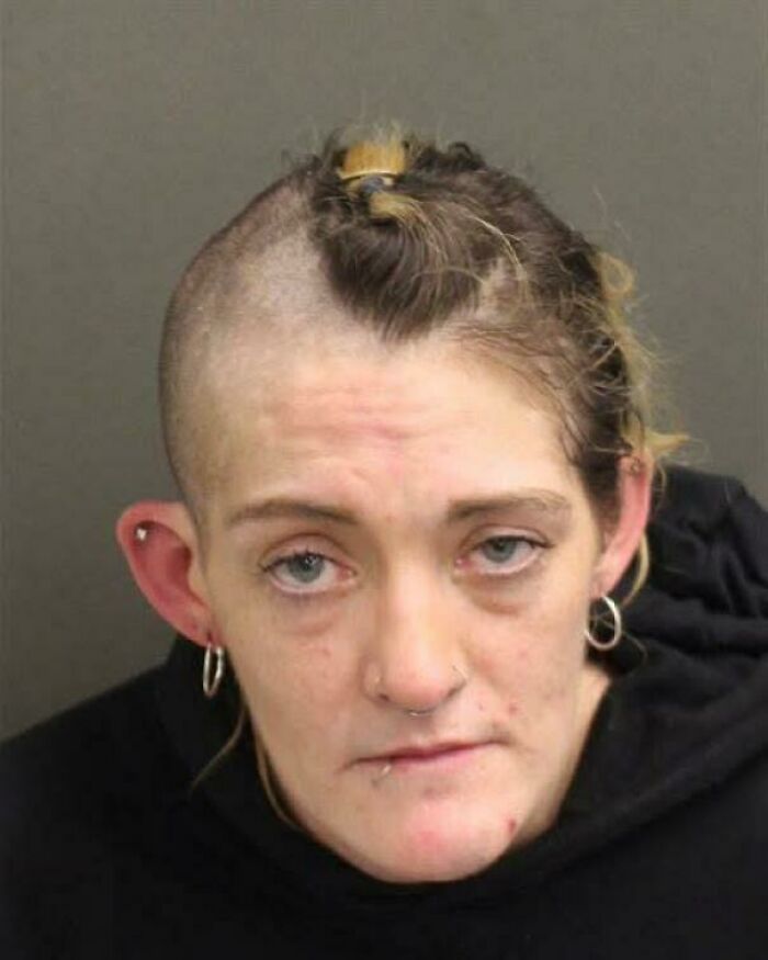 A woman with a partially shaved head and hair tied back, experiencing a bad hair day.