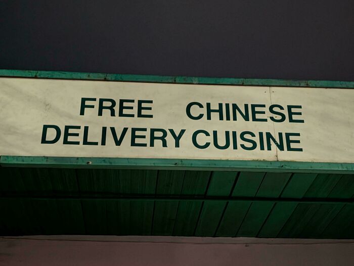A sign with a confusing message: 'FREE CHINESE DELIVERY CUISINE', suggesting poor sign design.
