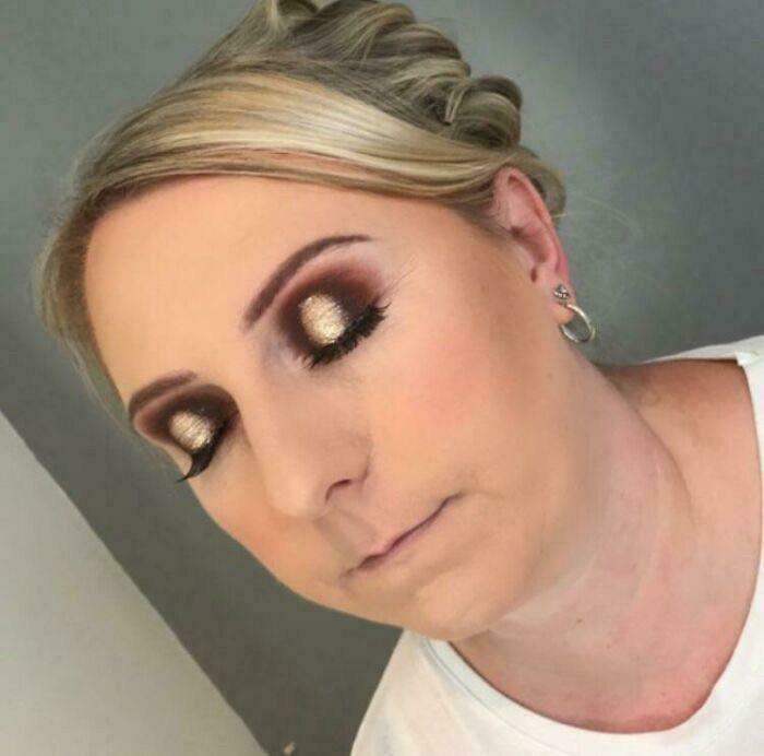 A woman with very heavy, mismatched gold and dark eyeshadow, a beauty salon makeup application looking significantly worse.