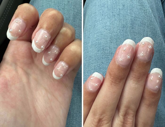 Hands with uneven, pearlescent French tip nails, a beauty salon service looking significantly worse.
