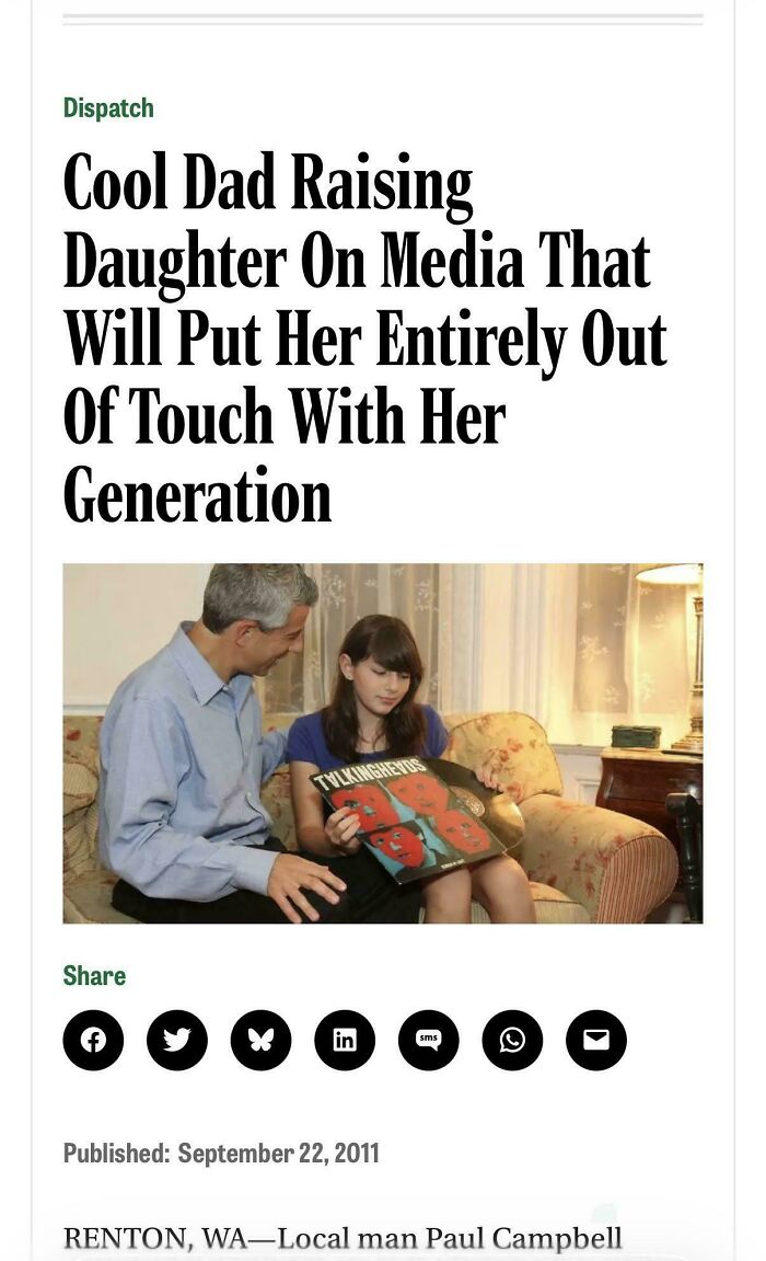 A cool dad and his daughter on a couch looking at a vinyl record, showcasing the wholesome and fun side of being a dad.