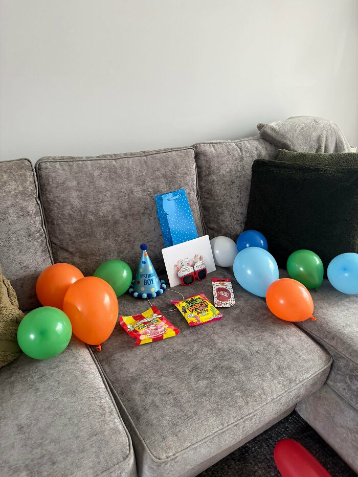 A couch with birthday decorations, including balloons, gifts, and a birthday hat, showing the fun side of being a dad.