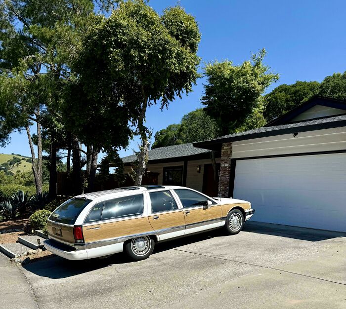 A vintage station wagon parked outside a house, representing a classic item a dad might own.